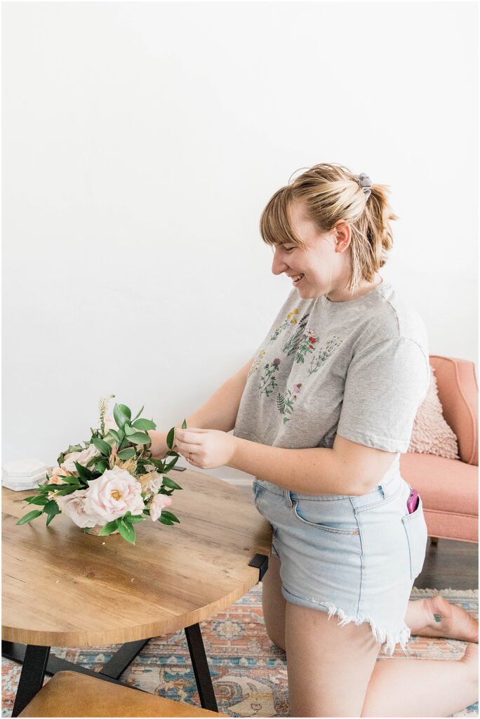 blonde woman arranging plants as home decor