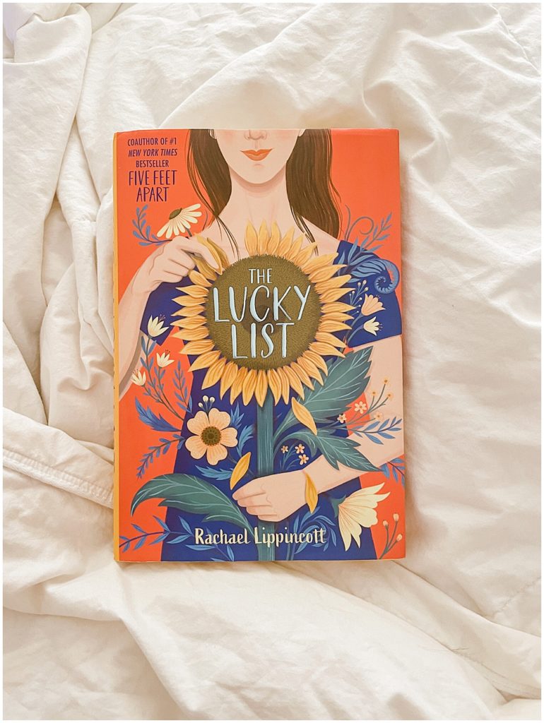 the lucky list by rachael lippincott on a bed with white blankets
