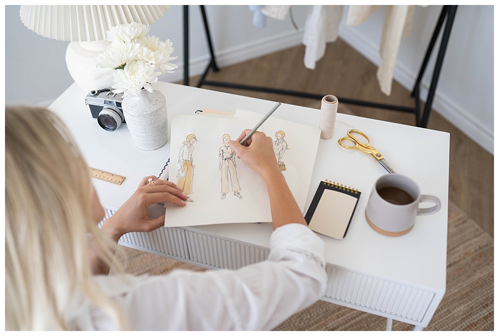 woman at desk drawing fashion designs