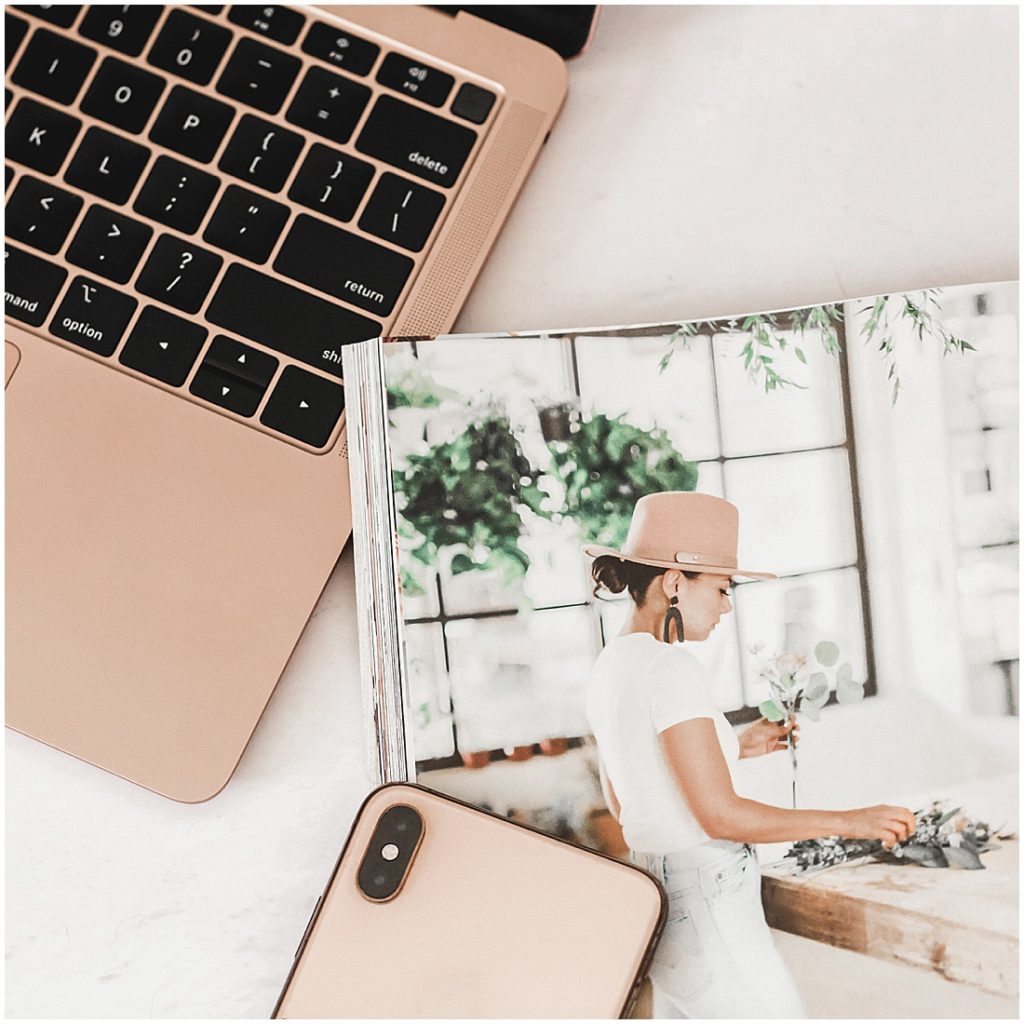 5 steps to organizing your phone photos - picture of laptop, magazine, and rose gold iphone on the bed