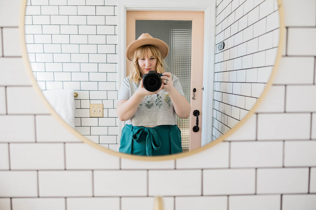5 Ways to Improve Your Relationship with Yourself - Sam taaking a photo of herself in a bathroom mirror