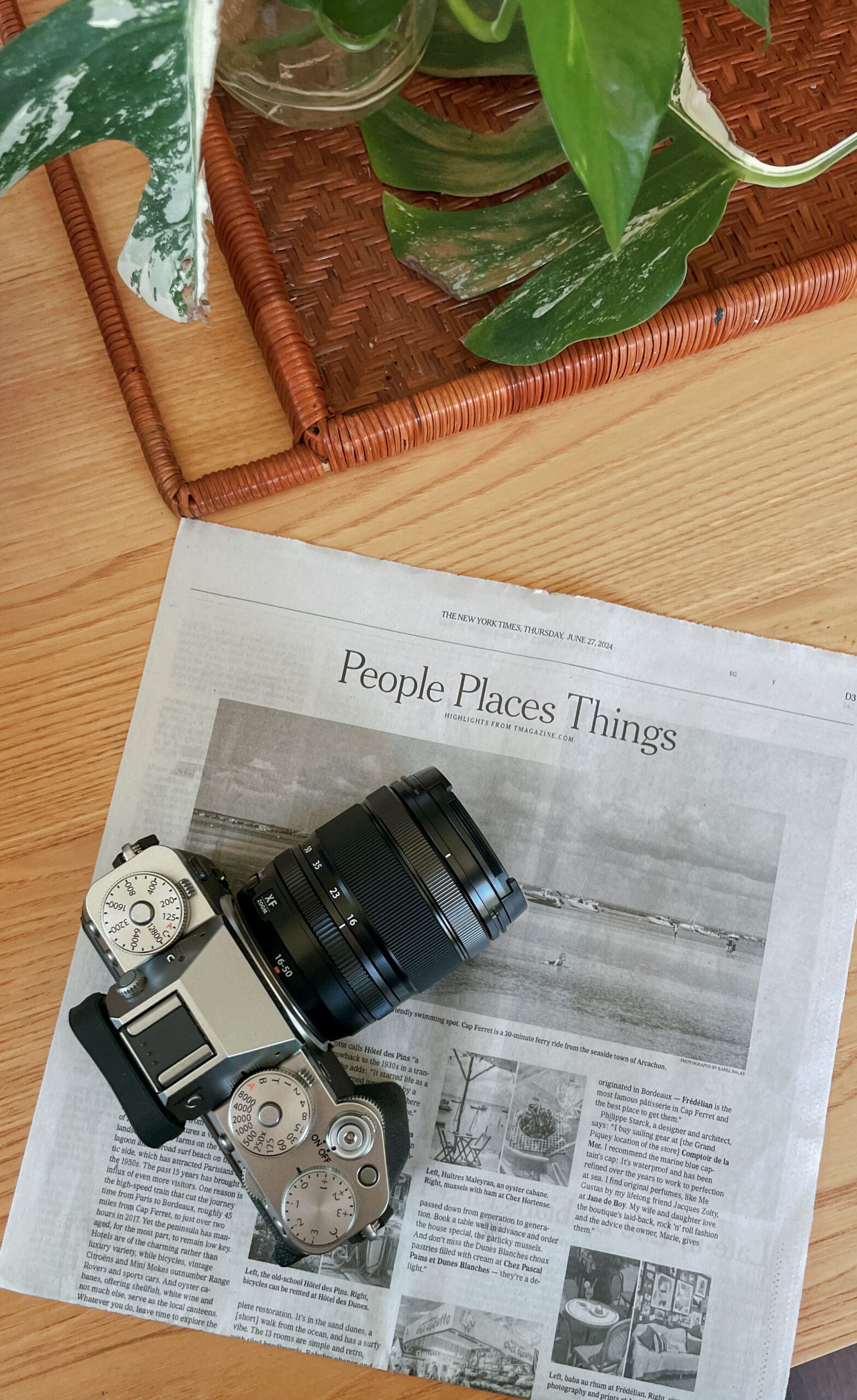 Newspaper on table with fujifilm camera sitting on top of it